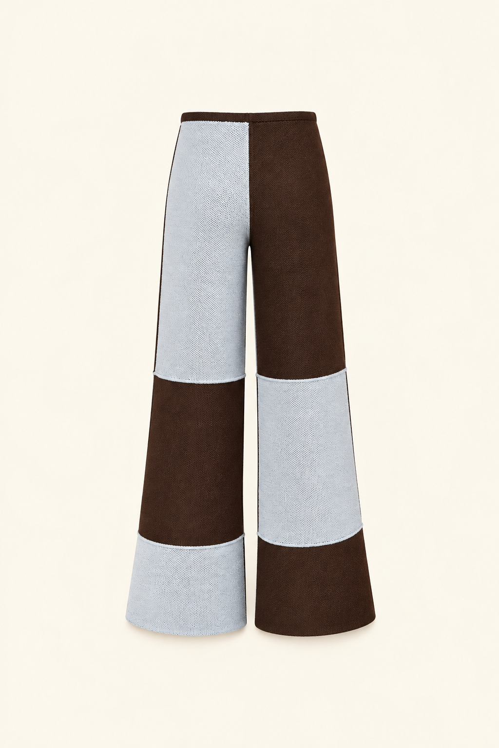 A pair of wide-leg cropped pants featuring a color-blocked design with dark brown and light gray panels, shown against a solid cream background.